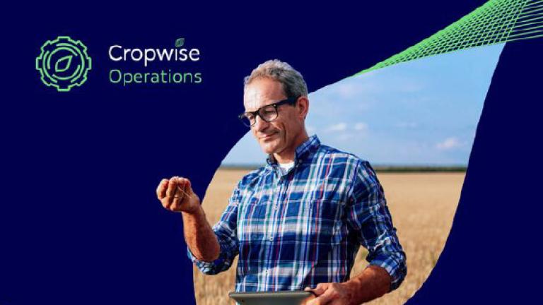 Hombre con gafas y camisa a cuadros sonriendo; fondo azul con logo de Cropwise Operations.